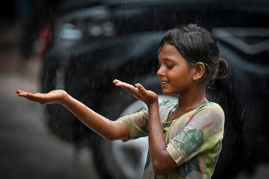 A girl plays in rain, in Bikaner, Rajasthan